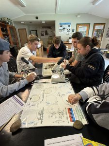 young teen students use microscopes in a classroom