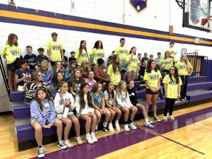 a group of students sit in a gymnasium
