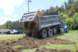 a dump truck drops a load of soil