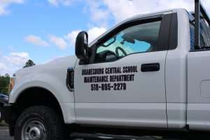 a white truck is labeled with "Duanesburg Central School" on the driver's side panel