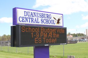 a digital sign tells voters where and when they can vote on the school budget