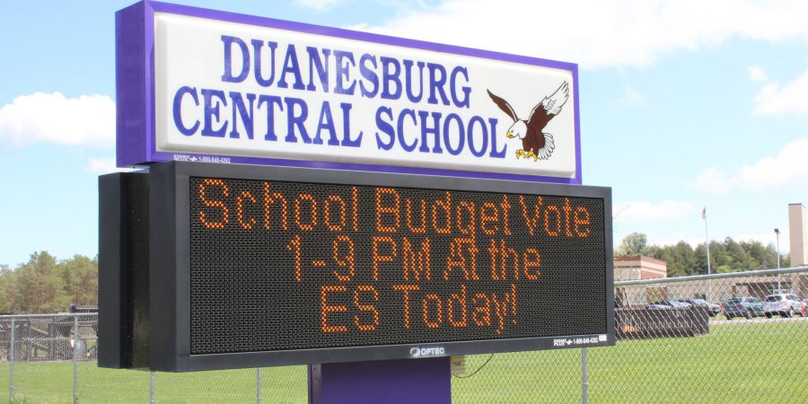 a digital sign tells voters where and when they can vote on the school budget