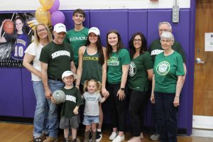 a family poses together all wearing green shirts