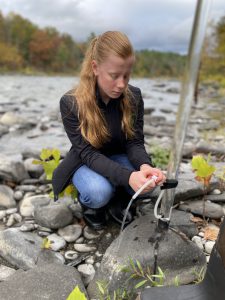 a young teen girl participates in an experiment on the shores of a creek
