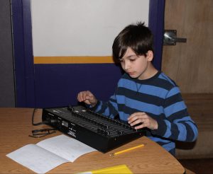 a young man uses an audio board during play rehearsal