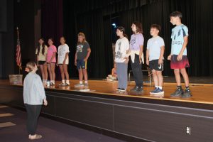 students rehearse a scene on stage