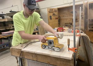 a young man is shown using a sanding machine