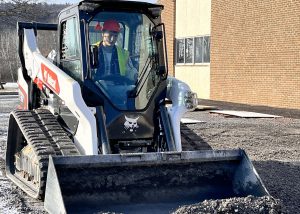 a young man operates an excavator