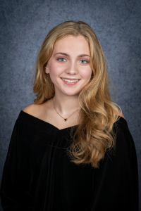 a blonde female teenager poses with a black top on