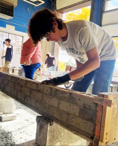 a young man is shown laying bricks