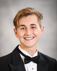 a boy with a bowtie poses for a senior portrait