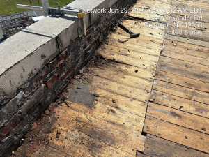deteriorating brick and wood is shown on a rooftop