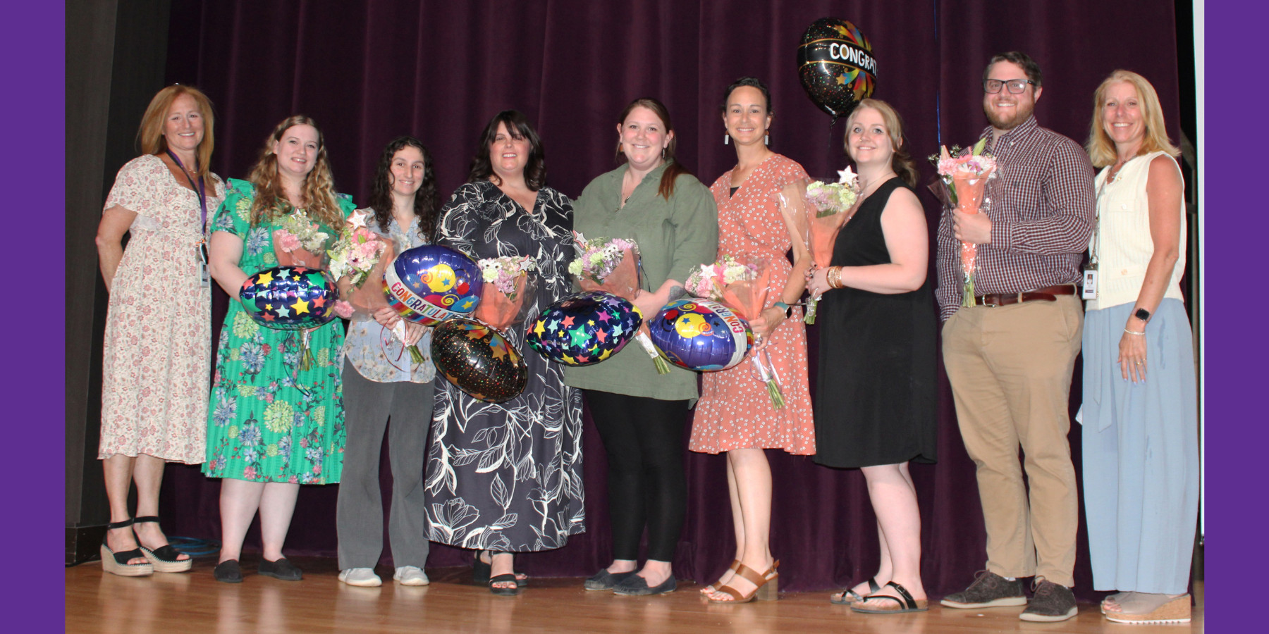 a group of teachers poses together on a theatrical stage