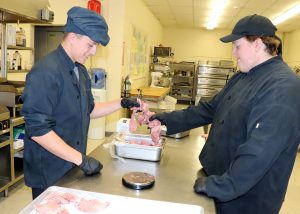 two young chefs cook in the kitchen