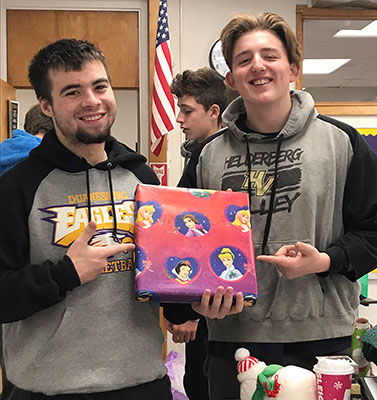 2 students holding wrapped gift