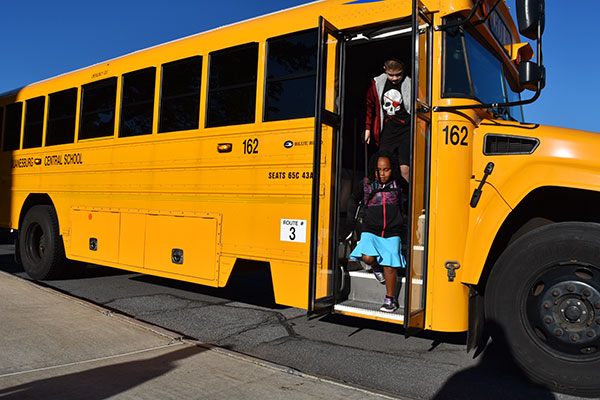 elementary students getting off their bus