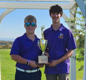 two teenaged boys hold a trophy
