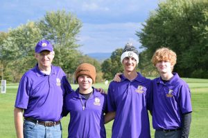 four golfers wearing purple shirts pose outside on a golf course