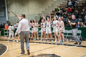 a team cheers on their coach who is holding a plaque