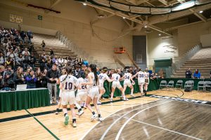 basketball players high five spectators in the stands