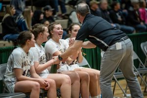 a coach congratulates his basketball team