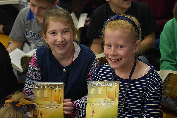 2 girls holding book by Kate DiCamillo