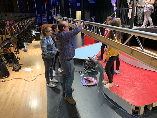 students and teacher working with rigging on stage