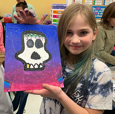 girl holding her sugar skull painting