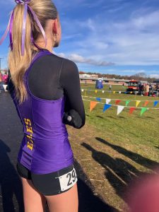 a young girl wearing a purple shirt prepares to run a race